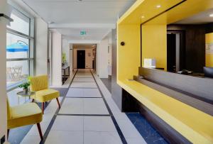 a hallway of a hospital with a yellow and white lobby at Best Western Hôtel Journel Antibes Juan-les-Pins in Antibes