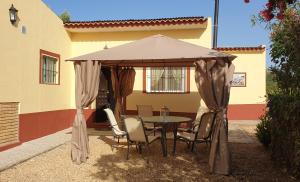 einen Tisch und Stühle unter einem Sonnenschirm auf einer Terrasse in der Unterkunft Finca-Vallestares in Almonte