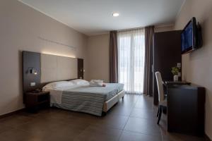 um quarto com uma cama e uma televisão de ecrã plano em Gimmi Hotel em Rimini