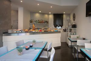 una sala da pranzo con 2 tavoli e una cucina di Gimmi Hotel a Rimini
