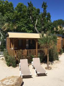 - deux chaises longues sur la plage en face d'une cabine dans l'établissement Marino Mobilhomes, à Grimaud