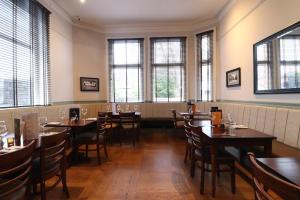 a dining room with tables and chairs and windows at The Bridge Inn Hotel in Bolton