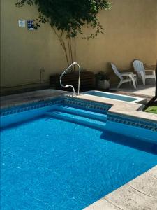 a swimming pool with blue water in a yard at Hotel Crillon Mendoza in Mendoza