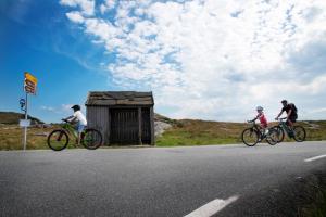a group of three people riding bikes down a road at Utstein Kloster Hotell in Mosterøy