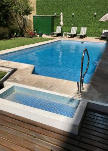 a swimming pool with a faucet in a yard at Hotel Crillon Mendoza in Mendoza