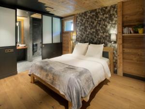 a bedroom with a large bed and a bathroom at Chalet 1703 - Alpine Lodge & Spa - Adults Only in Le Petit-Bornand-lès-Glières +36 photos