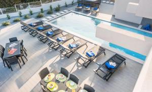 einen Blick über einen Pool mit Stühlen und Tischen in der Unterkunft Villa Bonita Brenda by Algarve Vacation in Armação de Pêra