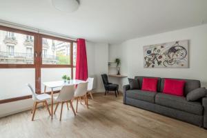 een woonkamer met een bank en een tafel bij Bright and cosy flat at the heart of Paris in a trendy district - Welkeys in Parijs