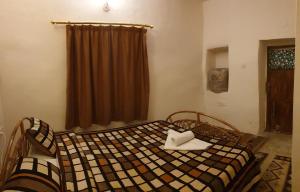 a bedroom with a bed with a checkered blanket at The Orient Home in Wadi Musa