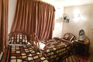 een slaapkamer met 2 bedden en een raam bij The Orient Home in Wadi Musa
