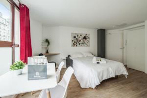 een slaapkamer met een bed en een tafel en stoelen bij Bright and cosy flat at the heart of Paris in a trendy district - Welkeys in Parijs