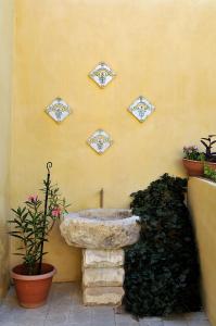 a stone sink on the side of a wall with plants at Il Giardino Del Barocco in Noto +25 photos