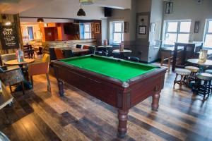 a pool table in a room with tables and chairs at Old Grey Mare Inn by Greene King Inns in Hull
