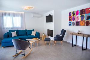 a living room with a blue couch and chairs at Adrianna Villa 4ppl in Bali