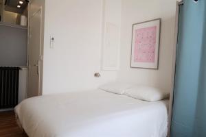 - une chambre avec un lit blanc et une photo sur le mur dans l'établissement La Terrasse de Wilson, à Toulouse