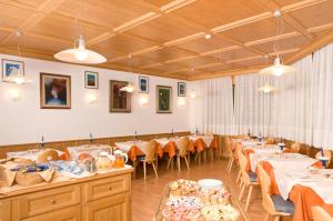 a large dining room with tables and chairs and lights at Albergo Antelao in San Vito di Cadore