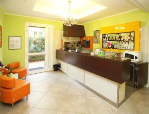 a kitchen with a bar with an orange chair at Hotel Alibi in Rimini