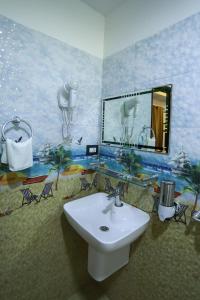 a bathroom with a sink and a painting on the wall at LEISURE VALLEY BEACH RESORT in Varkala