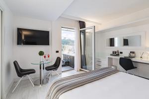 LHP Hotel River & SPA في فلورنسا: غرفة نوم بسرير وطاولة مع كراسي