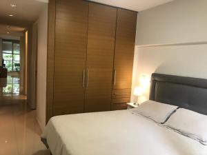 1 dormitorio con 1 cama blanca grande y armarios de madera en City Park Buenos Aires en Buenos Aires