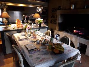 a table in a kitchen with a table and a fireplace at Le Mouton in Blaison