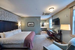 a hotel room with a bed and a desk and a chair at The Groton Inn in Groton