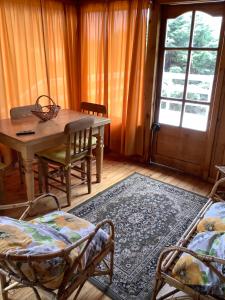 a room with a table and chairs and a table and a window at Lomita Quebrada in Pichilemu