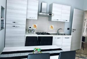 a kitchen with white cabinets and a sink at Ylli House Sanremo in Sanremo