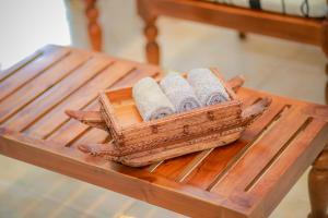 una pila de toallas enrolladas sobre una mesa de madera en VILLA No34 HIKKADUWA, en Hikkaduwa