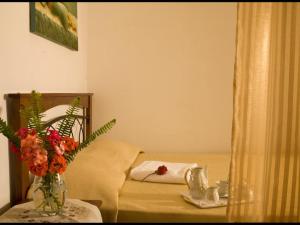 a room with a bed with a vase of flowers on a table at Creta guesthouse ARXONTIKO! in Smárion