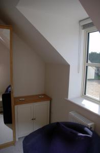 sala de estar con silla azul y ventana en The Starting Gate, Bruton, en Bruton