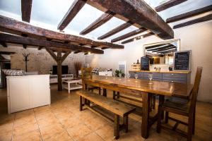 kuchnia z dużym drewnianym stołem i ławkami w obiekcie Charme et Spa dans un domaine d'élevage w mieście Sennevières