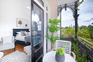 a room with a balcony with a bed and a bedroom at Designer Styled Studio in Central Trendy Glebe DUPLICATE in Sydney
