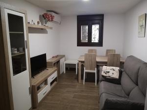 Una sala de estar con un sofá y una mesa de comedor. en Apartamento Rural La Brígida, Rubiaco, LAS HURDES nº TR-CC-295, en El Rubiaco