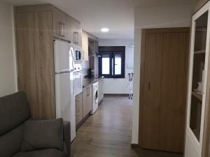 una cocina con electrodomésticos blancos y un sofá en una habitación en Apartamento Rural La Brígida, Rubiaco, LAS HURDES nº TR-CC-295, en El Rubiaco