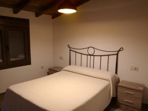 sypialnia z białym łóżkiem i lustrem w obiekcie Apartamento Rural La Brígida las hurdes w mieście El Rubiaco