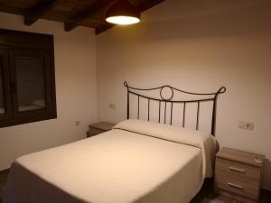 Un dormitorio con una cama blanca y un espejo. en Apartamento Rural La Brígida, Rubiaco, LAS HURDES nº TR-CC-295, en El Rubiaco