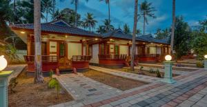 a home in a resort with palm trees at LEISURE VALLEY BEACH RESORT in Varkala