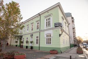 ein grün-weißes Gebäude in einer Stadtstraße in der Unterkunft Hotel Kutko in Pančevo
