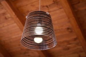 una luce in rattan appesa a un soffitto di legno di Agriturismo al Riparo dai Venti a Stintino