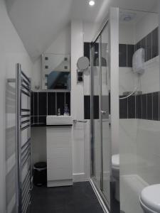 a white bathroom with a shower and a sink at South Beach B & B in Lowestoft +30 photos