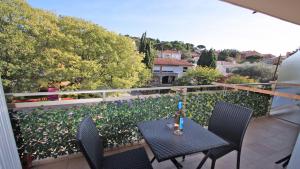 d'une table et de chaises sur un balcon avec vue. dans l'établissement Les Saisons, à Sainte-Maxime