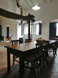 jadalnia z drewnianym stołem i krzesłami w obiekcie Intero alloggio - Casale a Sant'Alfio immerso nel verde w mieście SantʼAlfio