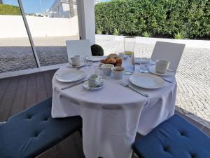 a white table with food and drinks on it at Vogue 23 Boutique Hotel in Cascais in Cascais
