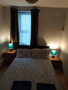 a bedroom with a bed with two lamps on tables at Mountjoy House in Derry Londonderry