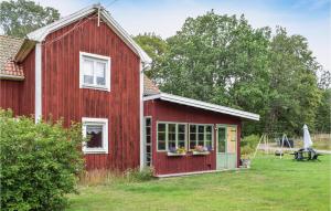 a red barn with a window and a swing at Nice Home In Ankarsrum With House A Panoramic View in Ankarsrum