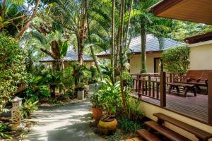 a porch of a house with benches and trees at Promtsuk Buri in Lamai