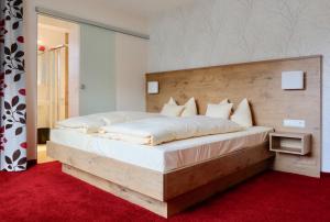 1 dormitorio con 1 cama grande y cabecero de madera en Hotel Renchtalblick, en Oberkirch