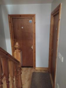 a hallway with a wooden door and a staircase at Mountjoy House in Derry Londonderry