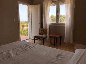 a bedroom with a bed and a chair and a window at Villa tosalet in Jávea